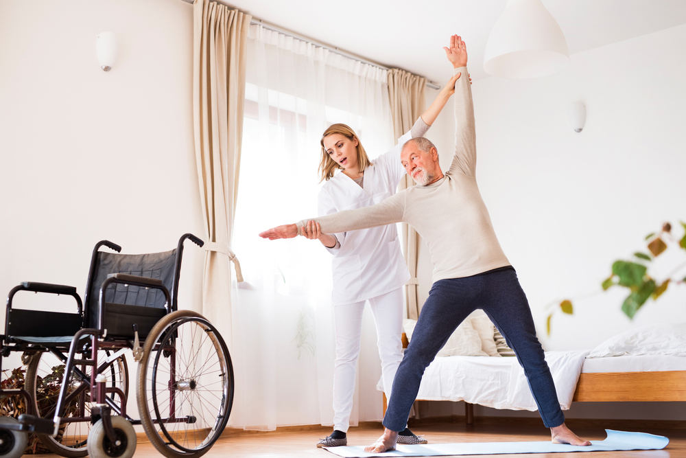 Health care worker helping patient do stretching exercises